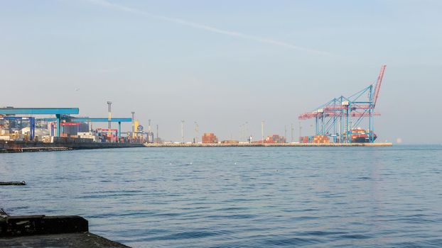 Commercial sea port in Odessa, Ukraine. March 2021. Panoramic view. Sea transport, container cranes