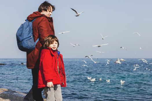 Dad with a small child walking on a winter beach. Weekend family activities