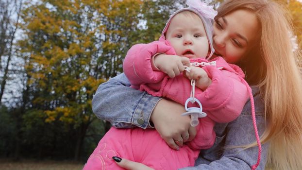 Young mother with her daughter on a warm autumn evening