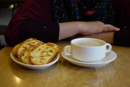 hand pick a garlic bread on a plate .