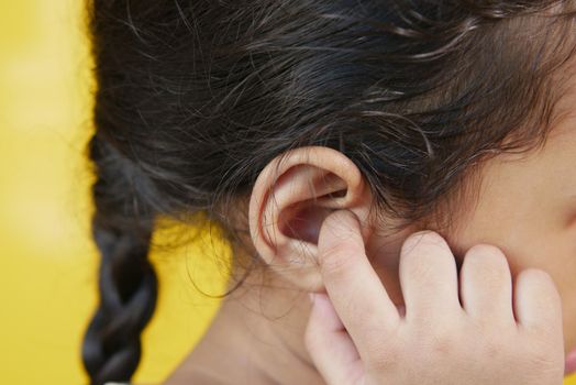 child girl having ear pain touching his painful ear ,.