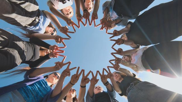 A group of girls makes a circle from their fingers