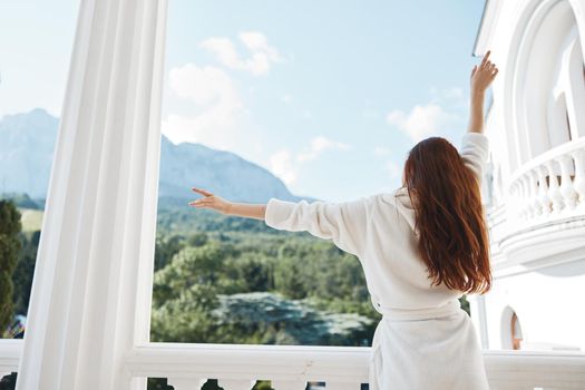 woman long hair in a white bathrobe staying on the balcony in a hotel Relaxation concept. High quality photo