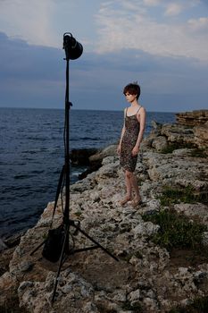 short haired woman in dress on nature rocks landscape outdoors. High quality photo