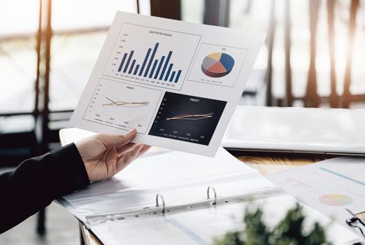 Businesswoman holding a sale performance paper to analyze sales profits