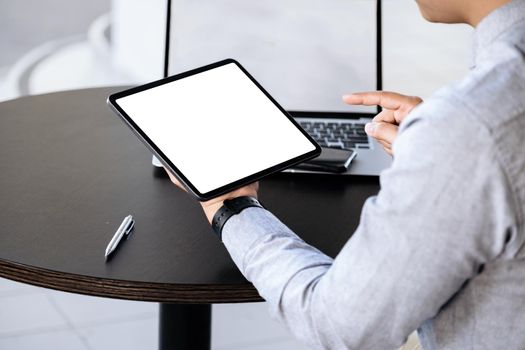 A man holding a tablet with a blank white screen. The blank space on the white screen can be used to write a message or place an image