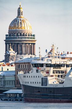 The panoramic view of the winter city Saint-Petersburg, big ship moored near Blagoveshchensky bridge, Isaac cathedral on background. High quality photo