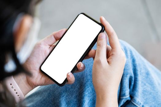 A woman holding a cell phone with a blank white screen. The blank space on the white screen can be used to write a message or place an image