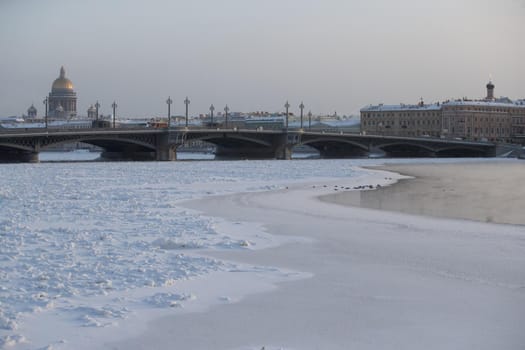Winter panoramic view of St. Petersburg at frosty day, Isaac cathedral and Blagoveshenskiy bridge on background, steam over frozen Neva river. High quality photo