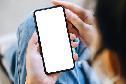 A woman holding a cell phone with a blank white screen. The blank space on the white screen can be used to write a message or place an image