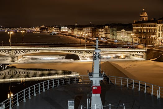 The panoramic footage of the winter night city Saint-Petersburg with picturesque reflection on water, big ship moored near Blagoveshchensky bridge or lieutenant Schmidt, Isaac cathedral on background. High quality photo