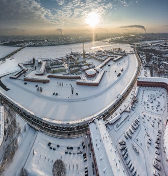 Drone point of view of winter St. Petersburg at sunset, frozen Neva river, steam over city, Peter and Paul fortress, car traffic on Trinity bridge, rostral columns, Palace drawbridge, panoramic view. High quality photo