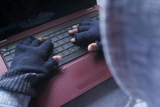 hacker hand stealing data from laptop top down.