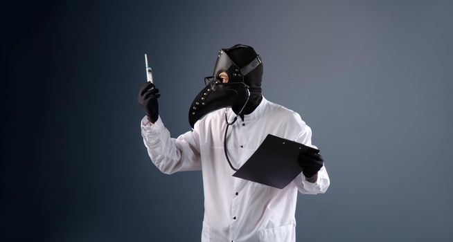 a doctor in a dressing gown, in a plague doctor's mask, is vaccinating