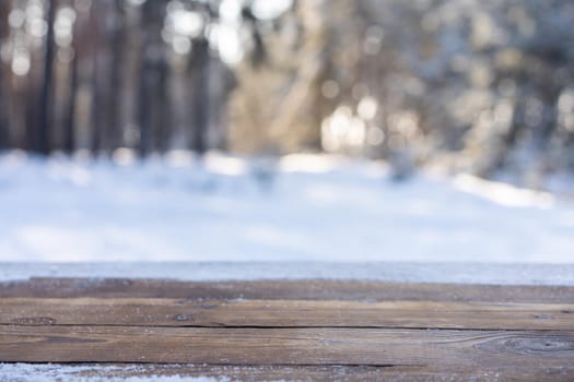 Beautiful winter scene. blurred background of snowy christmas nature background, Wood table top on shiny bokeh. For product display Christmas time mock up