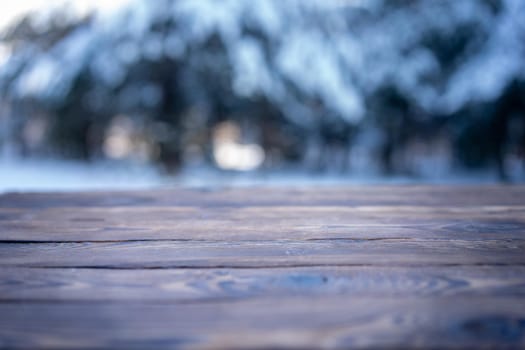 Beautiful winter scene. blurred background of snowy christmas nature background, Wood table top on shiny bokeh. For product display Christmas time mock up