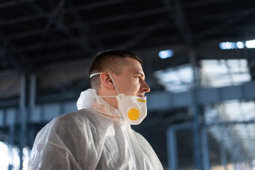 COVID-19 coronavirus doctor standing hospital parking dressed white protective overalls hazmat suit. Infectious disease pandemic medical worker front line, outbreak. Male medical worker medium shoot
