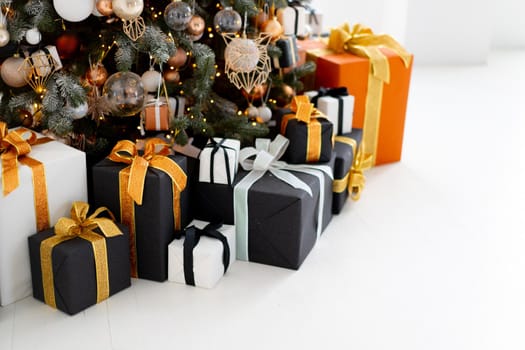 Christmas present box black, orange and white color on white floor with copy space. Holiday gift box