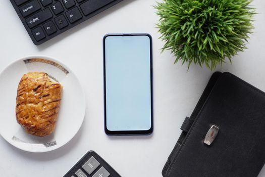 top view of smart phone and notepad on table .