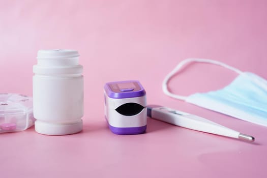 pulse oximeter, medical pills and blister pack on table .