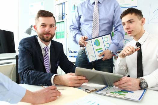 Group of business people discussing charts on paper and digital tablet. Business seminars concept