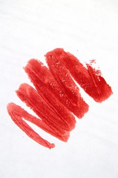 Close-up of a red lipstick smear on a white background.