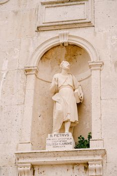 Statue of St. Peter on the stone facade of the Church of the Nativity of the Virgin in Prcanj. High quality photo