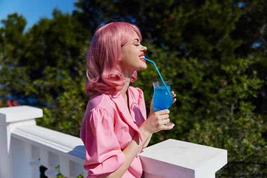 glamorous woman in pink dress outdoors with cocktail Drinking alcohol. High quality photo