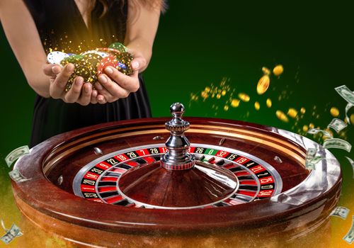 Collage of casino images with a close-up vibrant image of multicolored casino roulette table with poker chips in woman hands. Green background with golden sparks