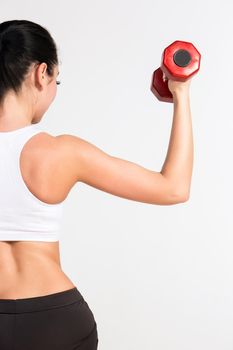 Sports young woman with dumbbells. studio shot. human half