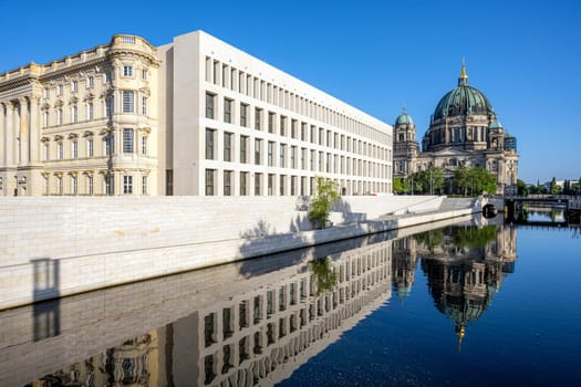 The Berliner Dom with the reconstructed City Palace reflected in the river Spree early in the morning