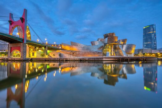 BILBAO, SPAIN - July 10, 2021: The futuristic Guggenheim Museum reflected in the River Nervion at dawn