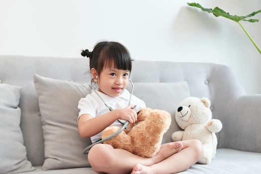 A doctor girl playing and cure bear at the pediatric