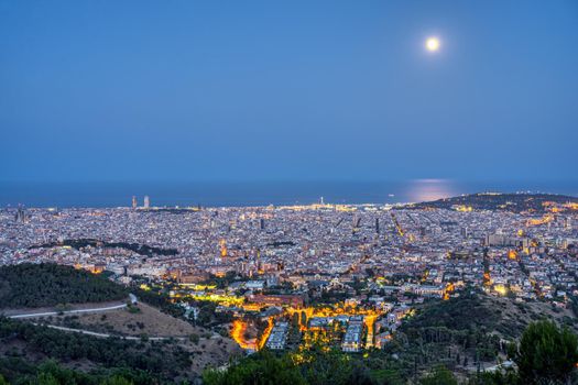 Night view of Barcelona from the Collserola mountain range during full moon