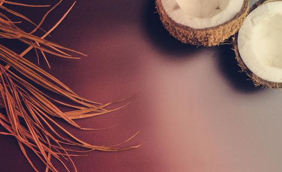 Summer composition with neon lights. Tropical palm leaves and broken coconut on a dark background. The concept of the summer season, parties and heat. Flat lay, top view, copy space