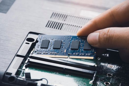 Technician install new RAM (Random-access memory) to memory slot on laptop motherboard
