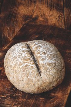 Freshly baked loaf of rye bread on cutting board