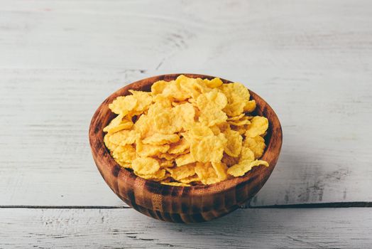 Rustic bowl of corn flakes over wooden surface
