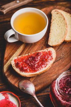 Toast with homemade raspberry jam with cup of green tea