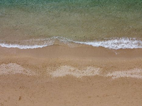 Timelapse. Beautiful remote beach with crystal clear water, aerial view. People sunbathe and swim on the pebble beach. Untouched nature, clean water. Rocky shore and hidden beach