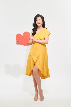 Portrait of attractive, pretty lady look at camera make hold paper red heart in hands isolated on shine teal background