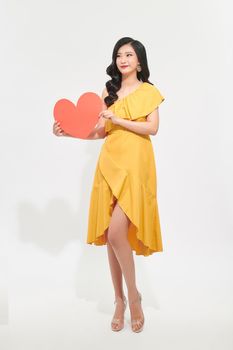 Woman holding big red heart on white background