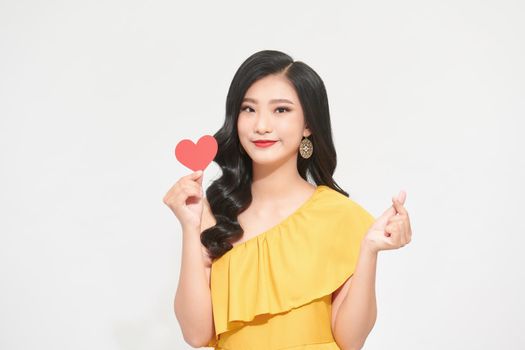 Portrait of attractive, pretty lady look at camera make hold paper red heart in hands isolated on shine teal background