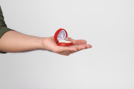 Close up of male hands holding wedding ring and gift box.