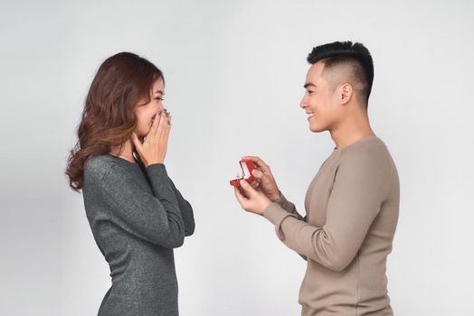 Asian man gives wedding ring and gift box to his woman
