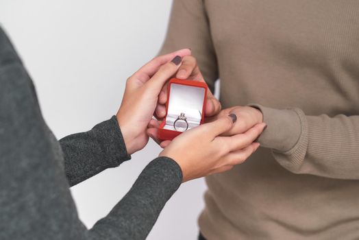 Asian man gives wedding ring and gift box to his woman