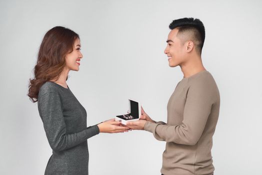 Asian man gives jewelry in a box to his woman