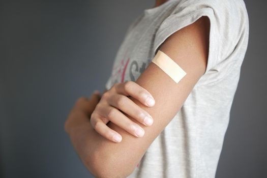 adhesive bandage on young man's arm .