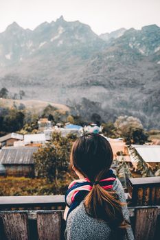 Portrait rear view of young woman looking and enjoying beautiful mountain scenery