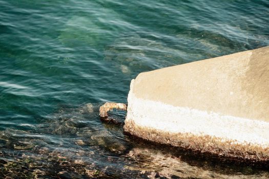 The seashore is reinforced with concrete tetrapods. Protection of the shore from blurring. Sea waves. Concrete tetrapod breakwaters lie all along the coast.